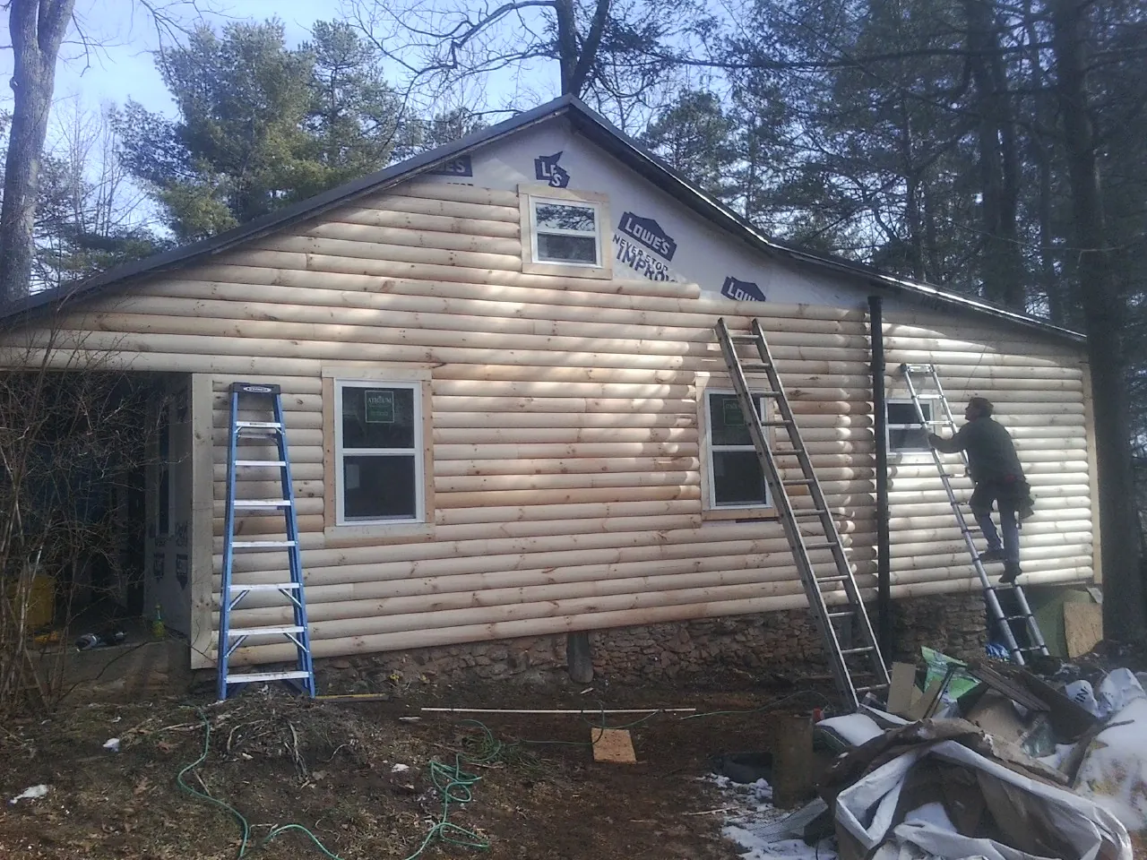 Ladders set against fresh log siding during an exterior remodel in Little Sioux