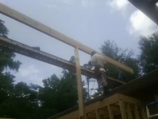 Carpenter setting a ridge beam over a new addition frame — Ice Dam Removal by Roofing Brothers in Little Sioux