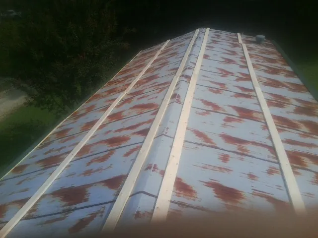 Rusted metal roof panels with new wood purlins before replacement — Storm Damage Roof Repair in Little Sioux by Roofing Brothers