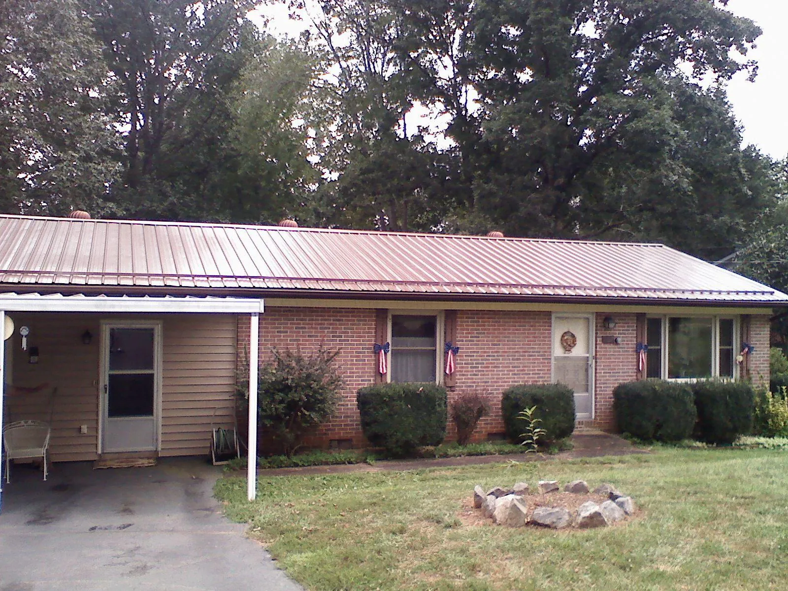 Bronze metal roof and carport on a brick ranch home — Roof Repair work by our crew in Little Sioux